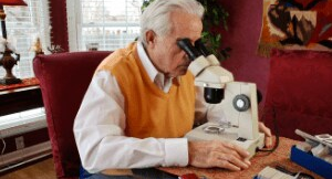 Man looking through microscopes in an office setting